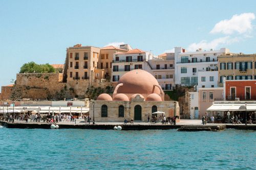 Free View of the iconic Venetian harbor in Chania, showcasing historic architecture and waterfront charm. Stock Photo
