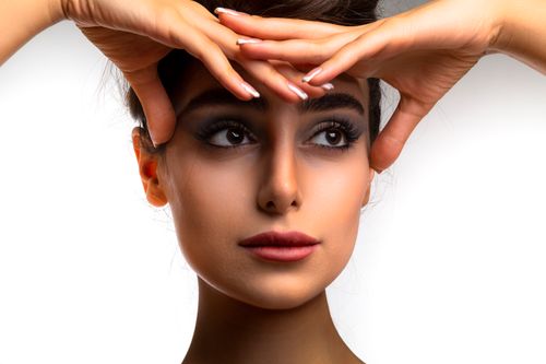 Free Close-up portrait of a woman with natural makeup, highlighting expressive eyes and flawless skin. Stock Photo