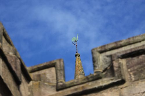 Free A weather vane on an ancient building in England against a blue sky. Stock Photo