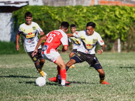 Players in action during an outdoor soccer match on a sunny day, showcasing vibrant teamwork.
