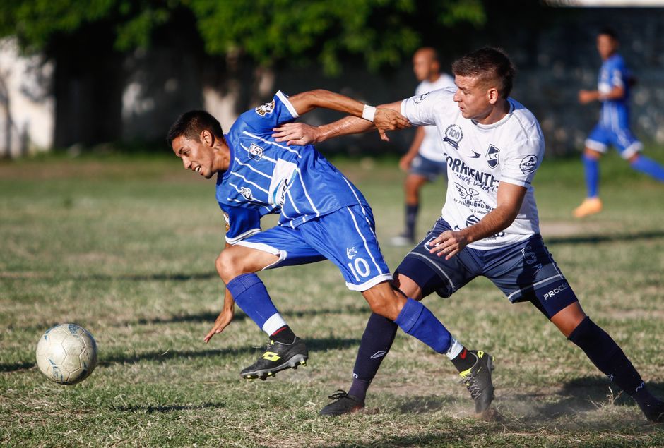 Dynamic action shot of players competing in a lively soccer match outdoors.