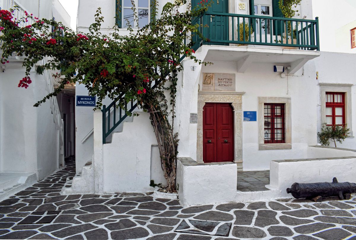 Alee cu pereti albi, balcon verde si bougainvillea