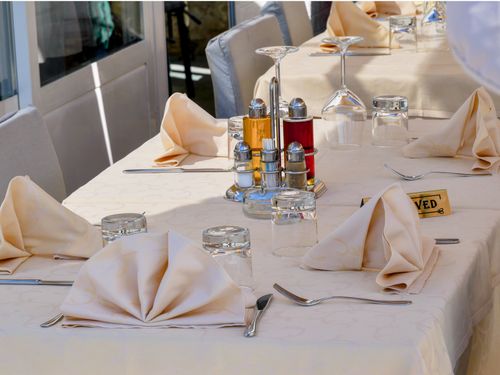 Free A beautifully arranged outdoor dining table with reserved sign, napkins, and condiments. Stock Photo