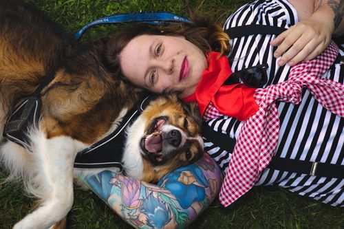 Free Joyful woman with her dog on grass in Kapfenberg, Austria. Perfect moment of relaxation and companionship. Stock Photo