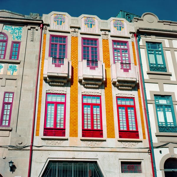 Painted tile facade with crimson window frames — photo by Efe Ersoy on Pexels