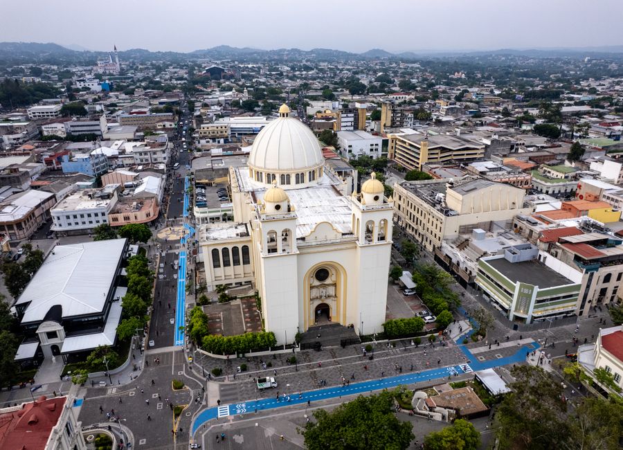 Aerial shot of the Metropolitan Cathedral in San Salvador's historic center, showcasing cityscape and urban architecture.