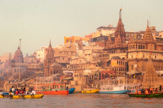 Vibrant boats and historic architecture along the Ghats of Varanasi, India.