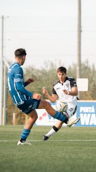 Action shot of two soccer players competing on a green field during a match.