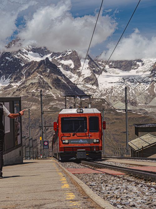Free A scenic mountain railway with a red train approaching a station in Zermatt, Switzerland. Stock Photo