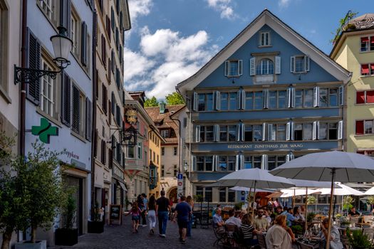 Outdoor dining and historic architecture on a vibrant Zurich street.