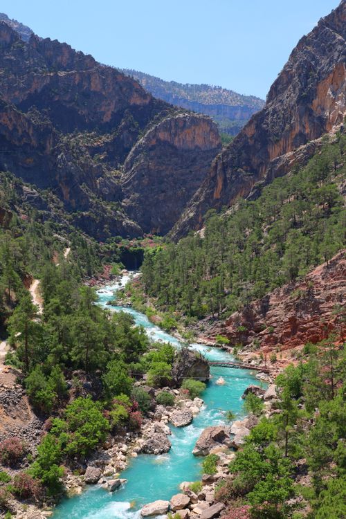 Free Stunning aerial shot of a turquoise river flowing through a lush, rocky canyon landscape. Stock Photo