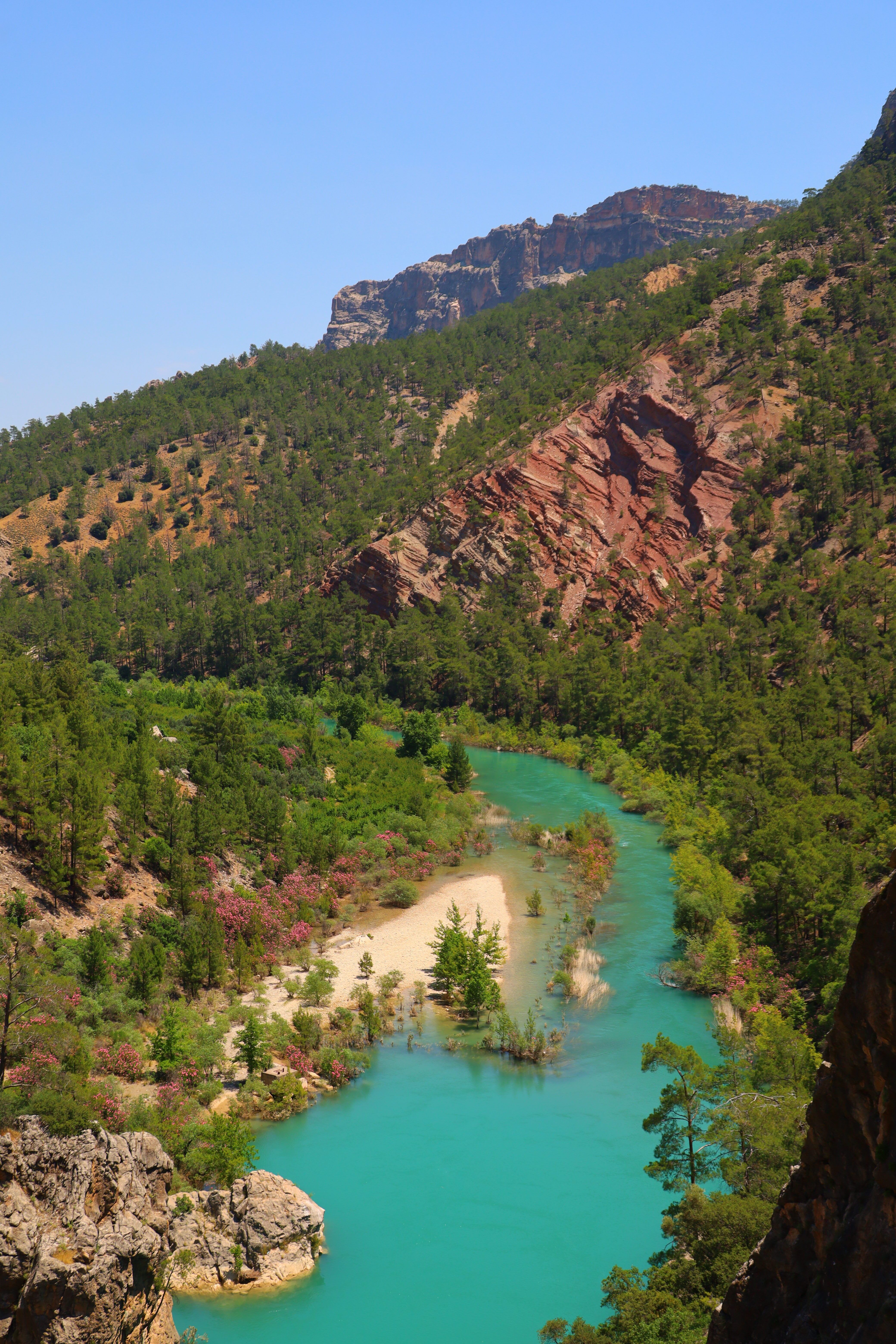 A breathtaking view of a turquoise river winding through a lush, rugged canyon.