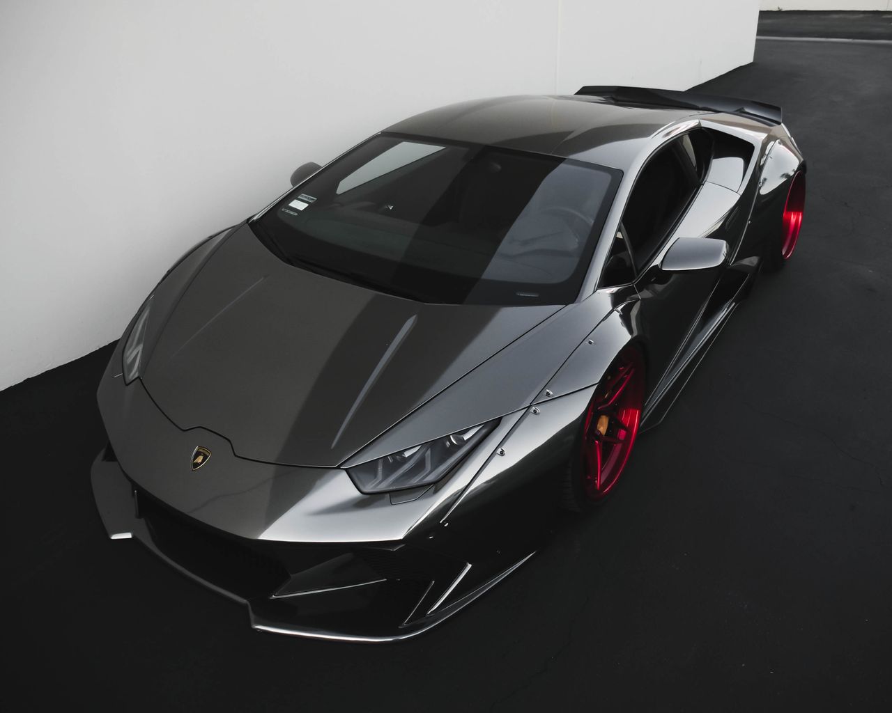sleek metallic lamborghini sports car with vibrant red wheels parked i