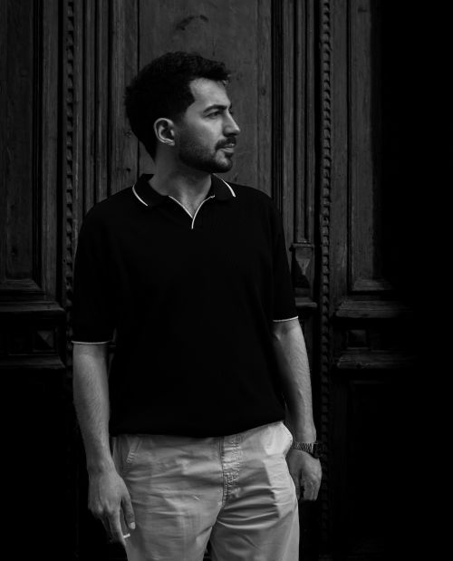 Free Artistic black and white portrait of a man standing against a wooden door in Baku, Azerbaijan. Stock Photo