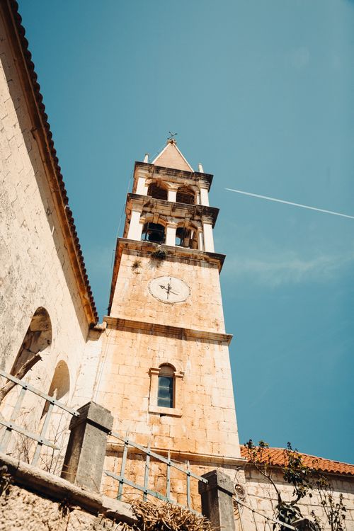 Free A historic church tower rises against a vibrant blue sky in Split-Dalmatia County, Croatia. Stock Photo