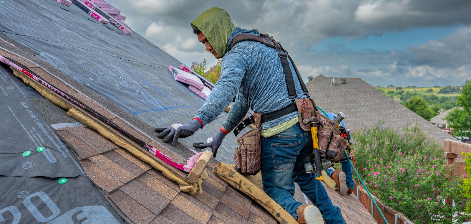 Roofers installing asphalt shingles on a Texas home