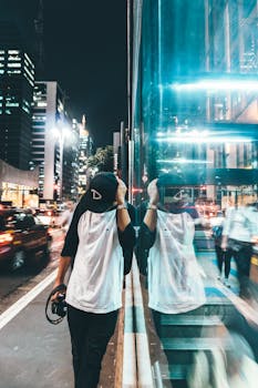 夜晚的城市场景中，时尚的男人和充满活力的街道倒映在光影里