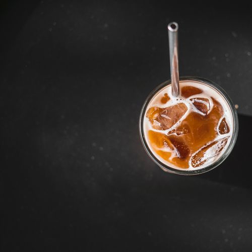 Free Top view of a refreshing iced coffee with milk on a dark surface, perfect for summer vibes. Stock Photo