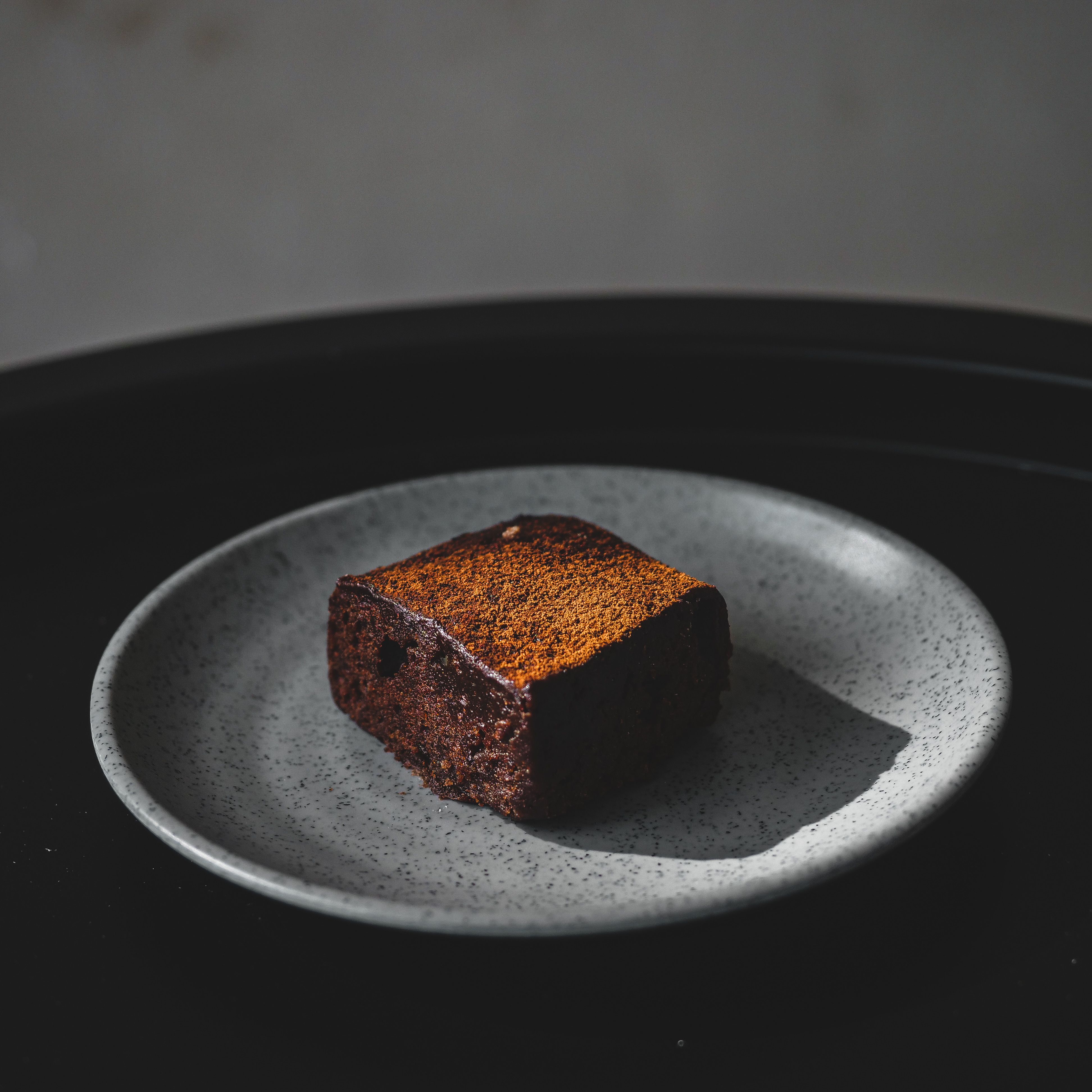 Rich and indulgent chocolate brownie served on a stylish stoneware plate.