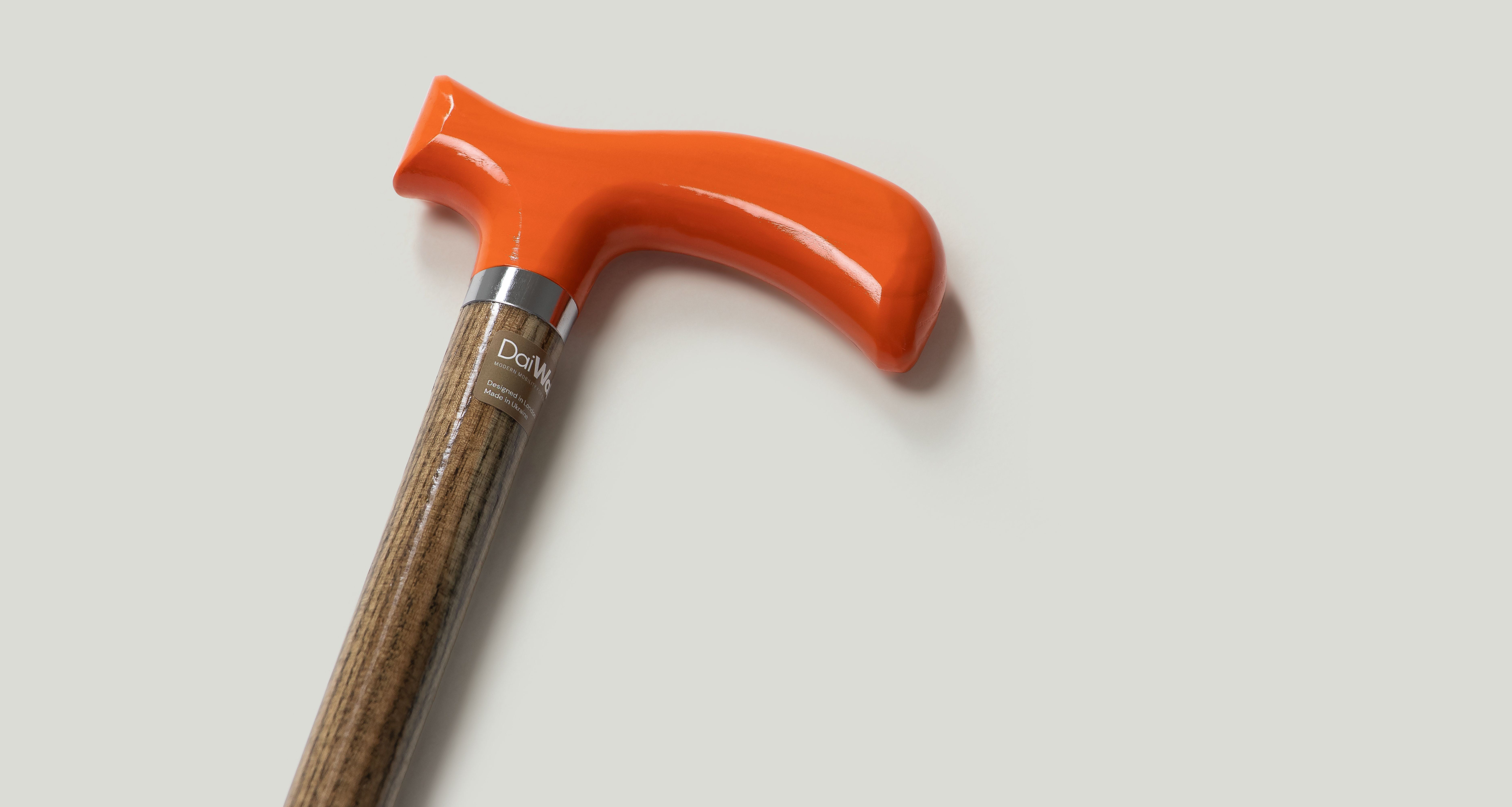 Elegant walking cane with vibrant orange handle and wooden shaft for reliable support.