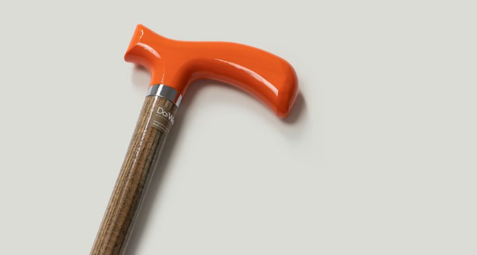 Elegant walking cane with vibrant orange handle and wooden shaft for reliable support.