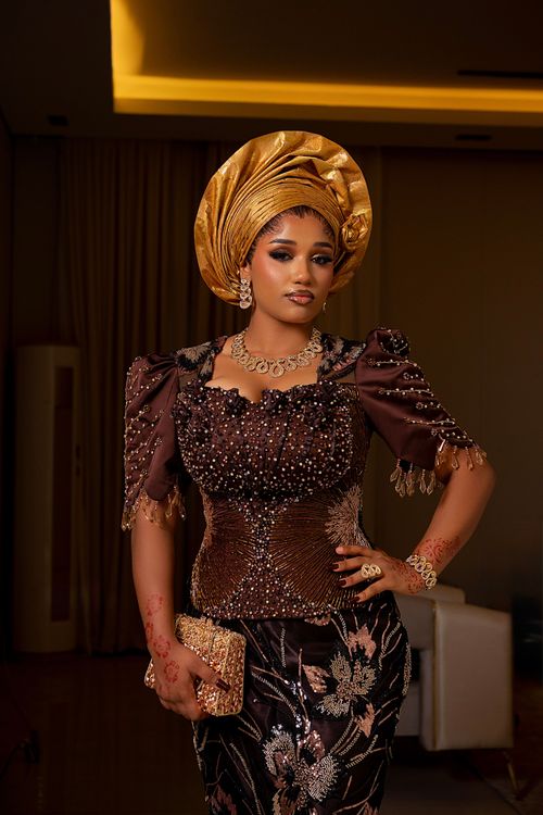 Free A beautiful Nigerian woman wearing traditional attire with intricate designs indoors. Stock Photo