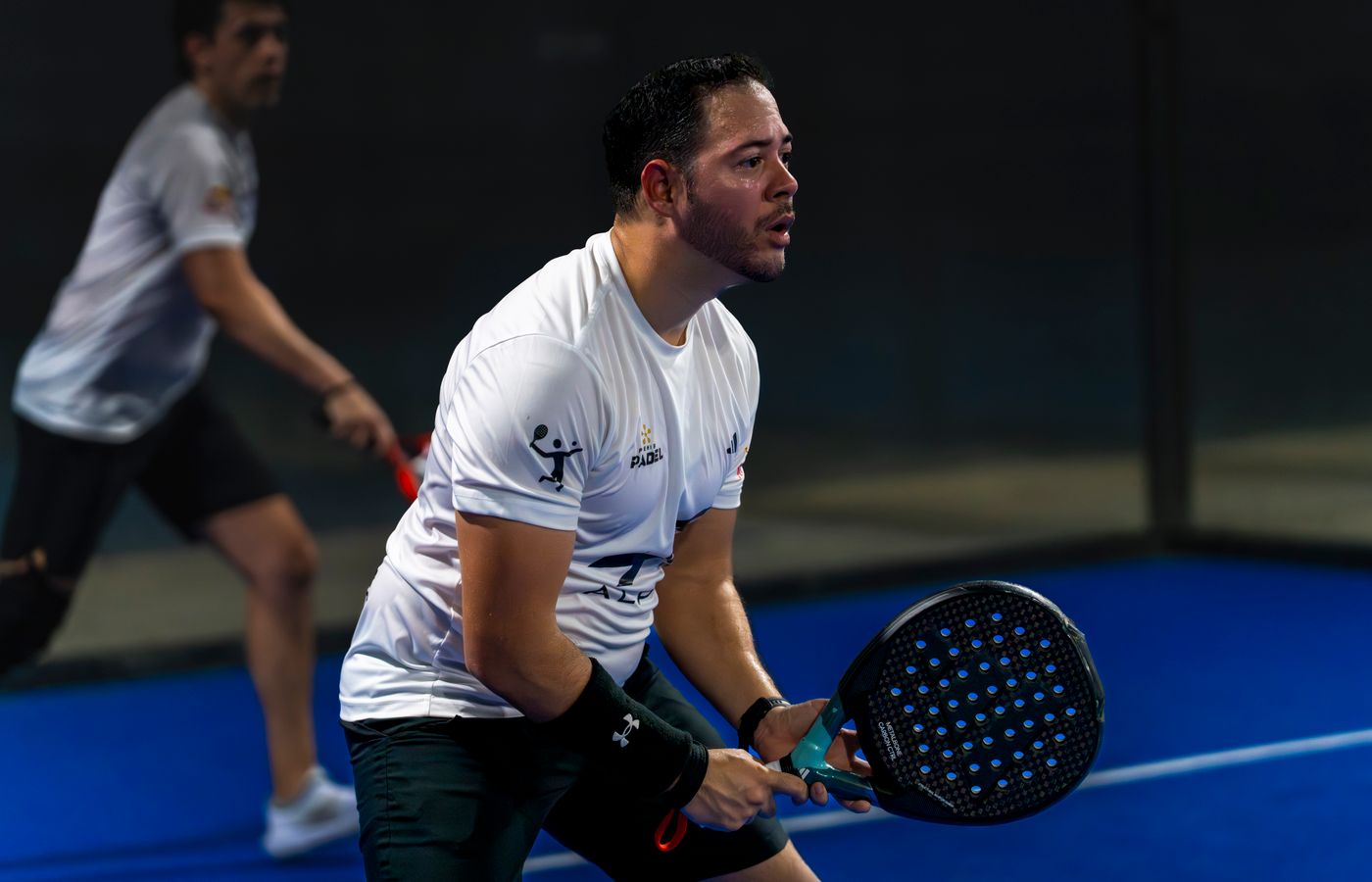 Two padel players working together on an indoor court