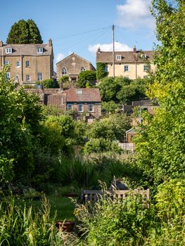 Scenic summer view of traditional houses amidst lush gardens in Malmesbury, England.