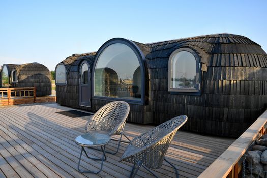 Eco-friendly glamping pods on a spacious wooden deck in Tallinn, Estonia. Perfect for a unique summer getaway.