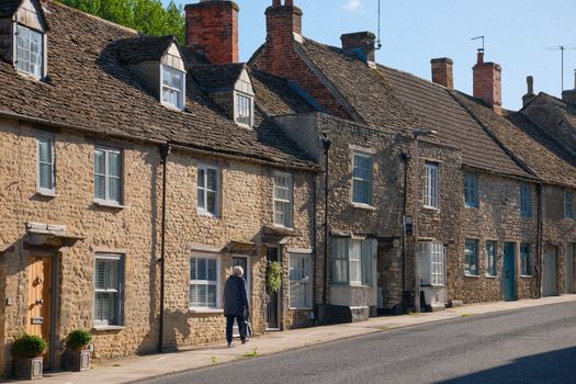 Picturesque stone cottages on a sunny day in Malmesbury, England, showcasing classic rural architecture.