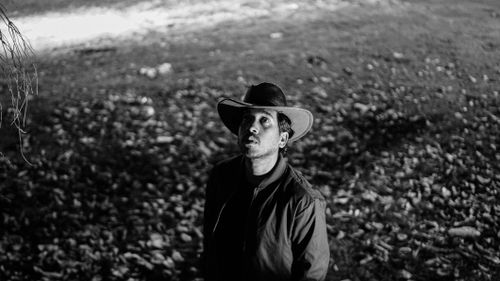 Free An artistic black and white portrait of a man in a hat looking up outdoors. Stock Photo
