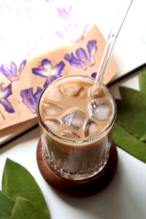 Free A glass of iced coffee with a floral background, capturing a cool and artistic vibe. Stock Photo