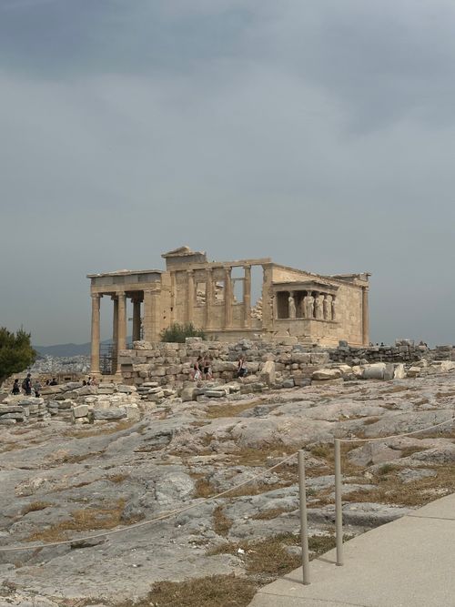 Free View of the historic Erechtheion Temple on the Acropolis in Athens, Greece, under a cloudy sky. Stock Photo