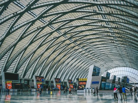Spacious indoor view of a modern airport terminal with futuristic, arched architecture.