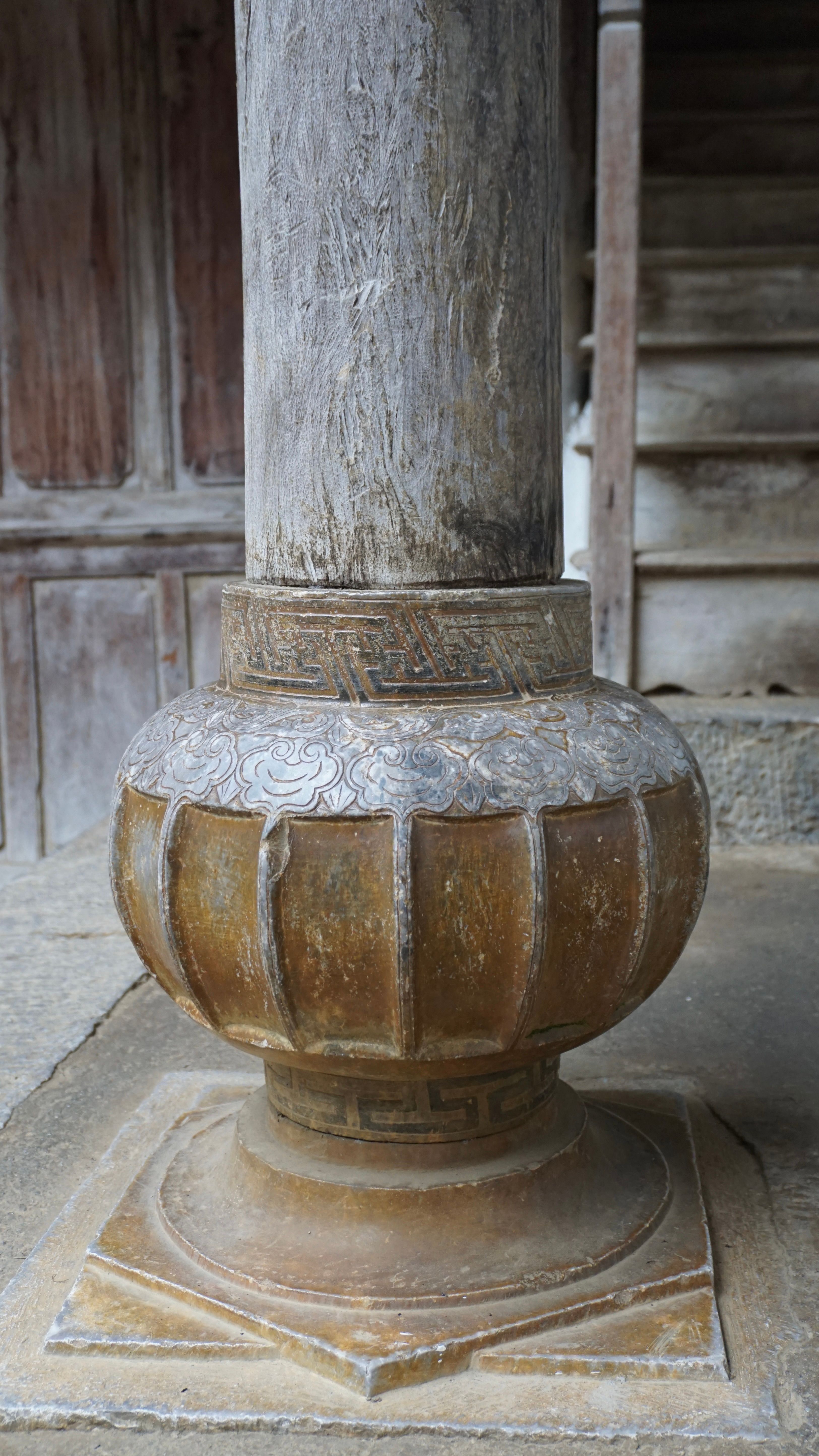 Close-up of an ornate stone column base, part of historical architecture in Sa Phin, Vietnam.