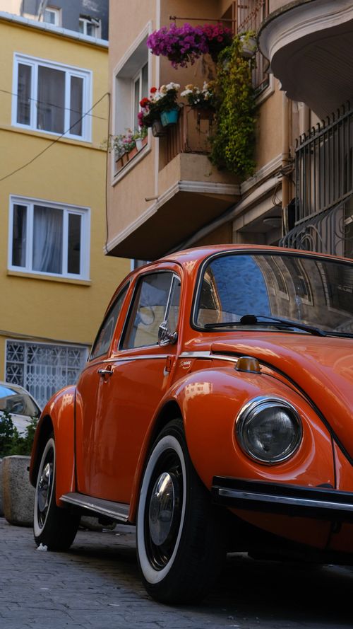 Free Vintage orange Volkswagen Beetle parked on a charming street in Istanbul, Türkiye. Stock Photo