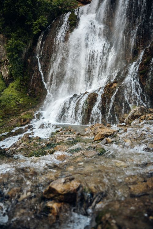 Free A breathtaking view of a cascading waterfall amidst a lush green forest, showcasing nature's beauty. Stock Photo