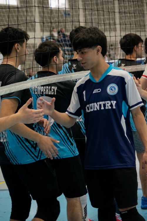 Free Volleyball players in jerseys shaking hands after an indoor match. Stock Photo