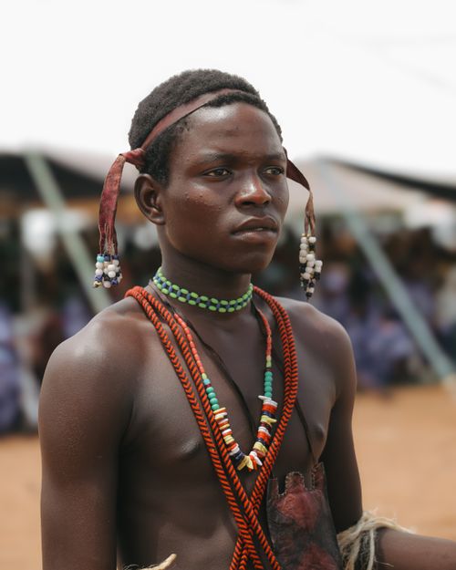 Free Portrait of a young man in traditional African attire at an outdoor cultural event. Stock Photo