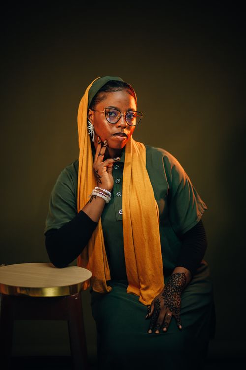 Free Portrait of a fashionable Nigerian woman in traditional attire with henna designs, photographed indoors. Stock Photo