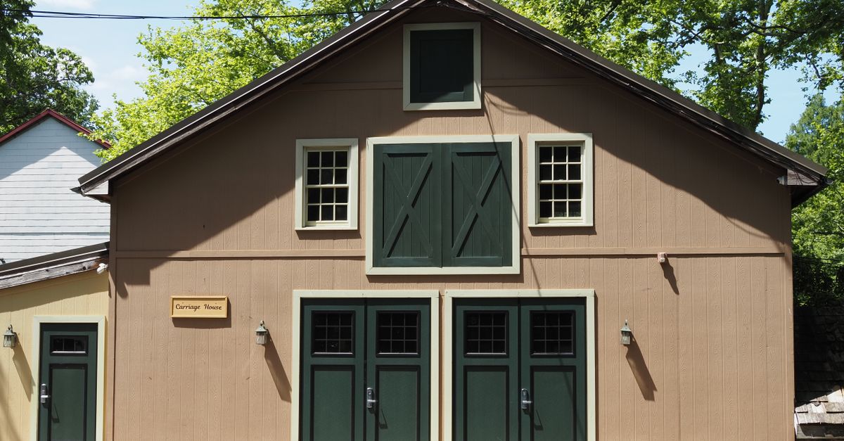 A picturesque view of a historic carriage house amidst lush greenery in Pennsylvania, United States.