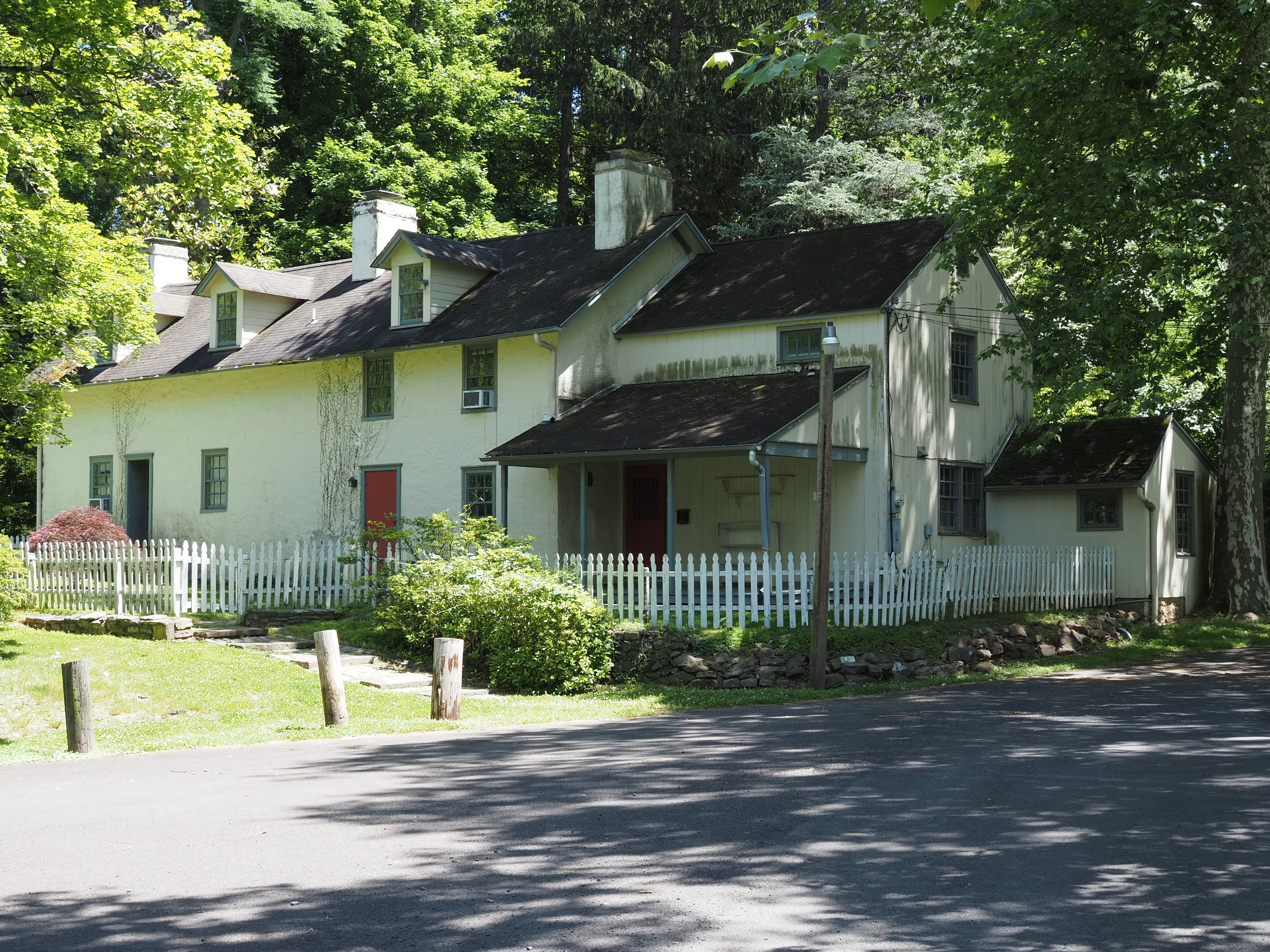Historic colonial-style house surrounded by lush greenery in Pennsylvania, USA.