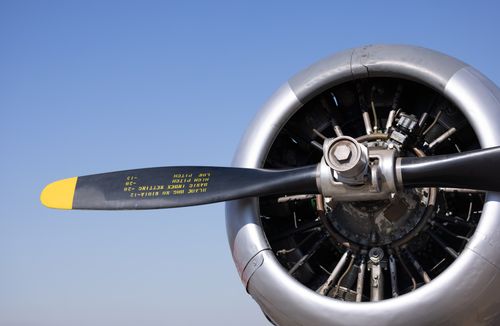 Free Detailed view of a classic airplane propeller with visible text under a clear blue sky. Stock Photo