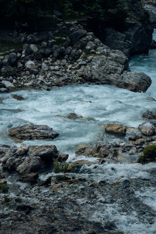 Free Scenic view of a river with powerful flow surrounded by rugged rocks and lush greenery. Stock Photo