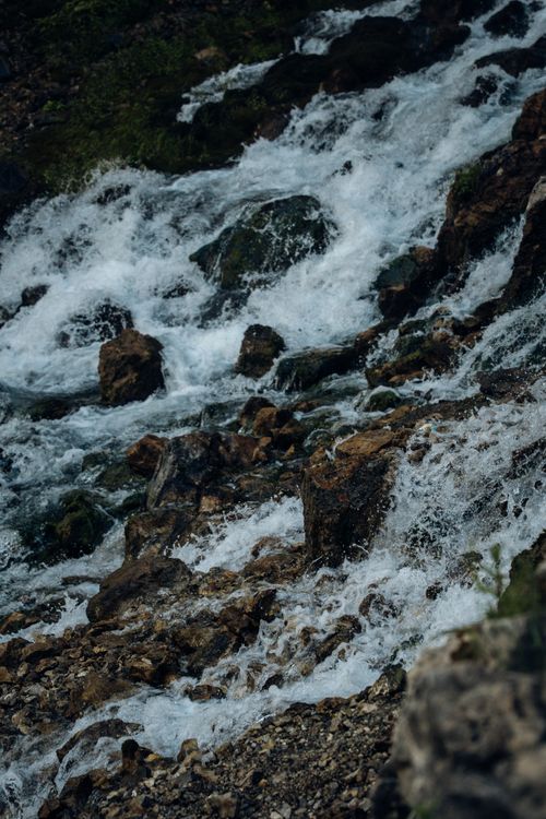 Free A vibrant mountain stream cascading over rocks, highlighting nature's beauty. Stock Photo