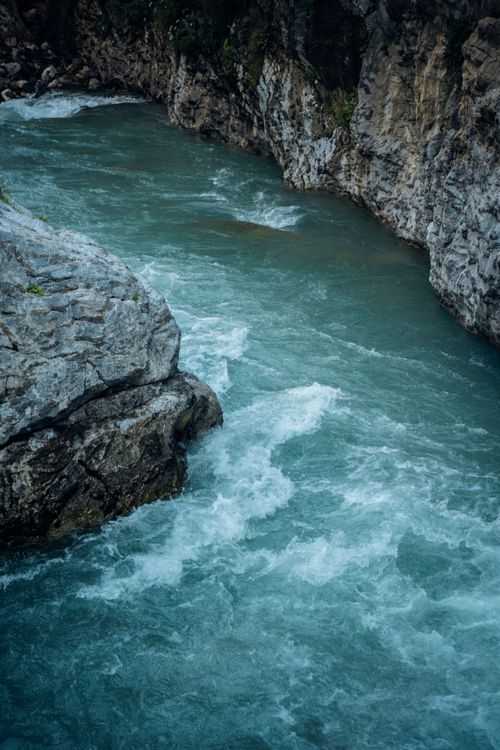 Free Dynamic view of a vibrant river flowing through a rocky canyon, showcasing nature's force. Stock Photo