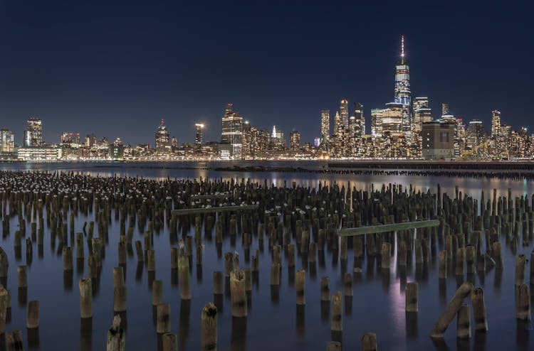 Modern City Skyline On Riverbank At Night