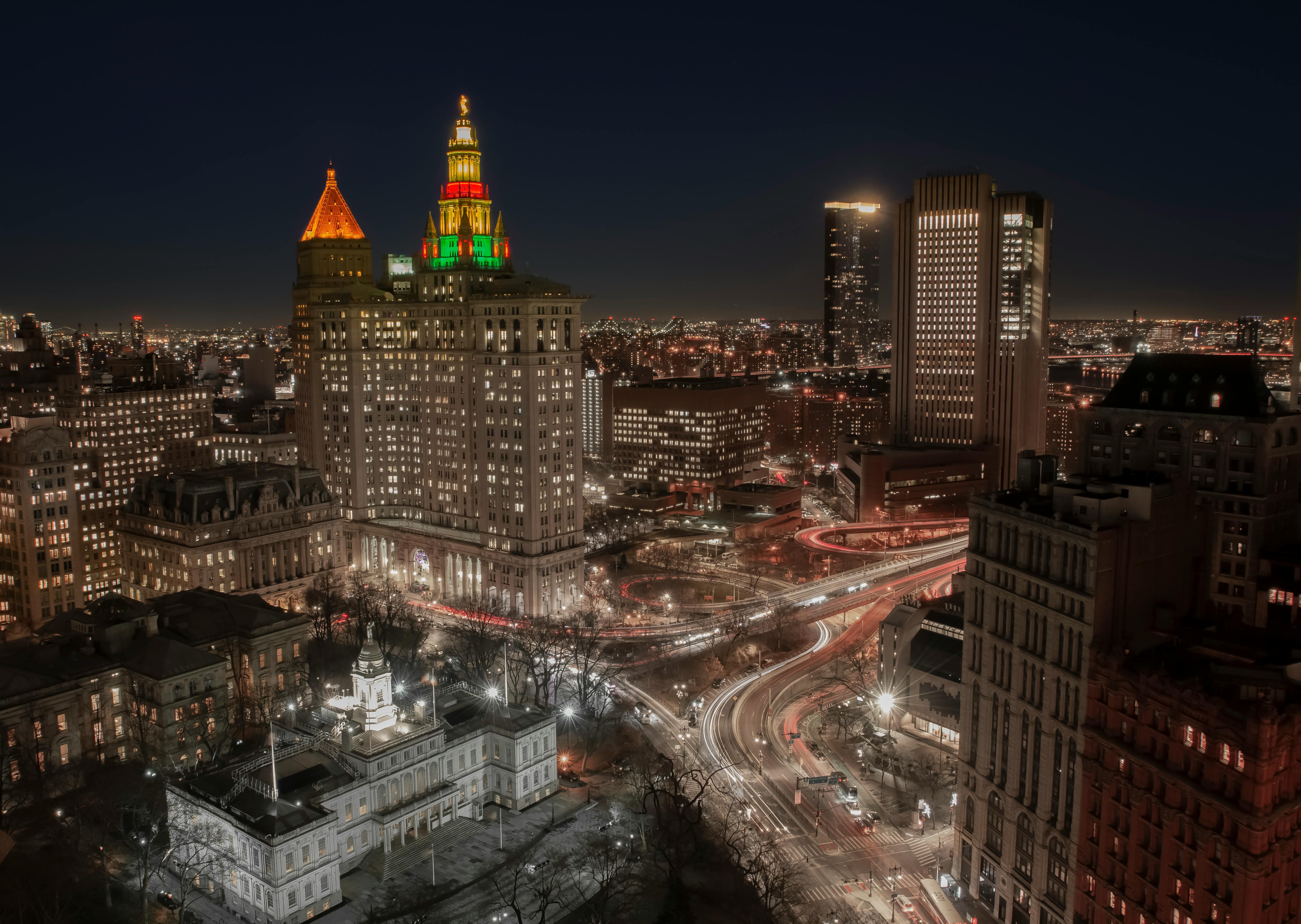 aerial photo of city with high rise buildings during night time