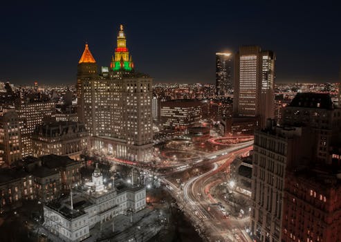 从高空俯瞰纽约市迷人的夜景，灯火通明的摩天大楼与繁华的街道尽收眼底