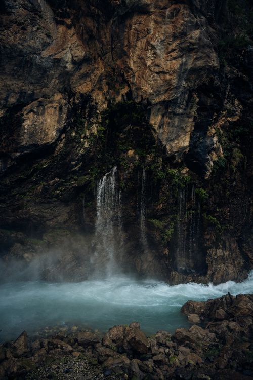 Free A tranquil waterfall cascading over rugged rocks into a peaceful pool, creating a serene natural scene. Stock Photo